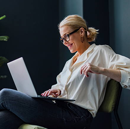 Business person sitting in chair using a laptop.